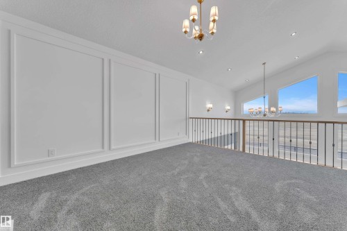 Upper-level space featuring grey carpet flooring, wall paneling, and an open railing overlooking the lower level - 13128 187 Avenue, Edmonton, AB - Indoor Photo Showing Other Room