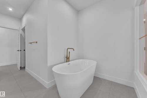 Modern freestanding soaking tub with a brass floor-mounted faucet - 13128 187 Avenue, Edmonton, AB - Indoor Photo Showing Bathroom