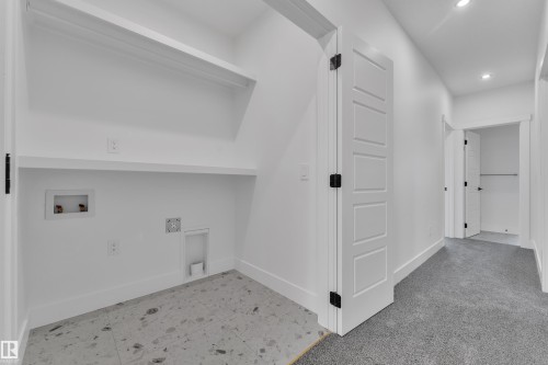 Laundry area with white walls, tiled flooring, and built-in shelving - 13128 187 Avenue, Edmonton, AB - Indoor Photo Showing Other Room