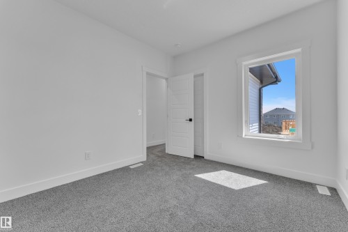 Neutral-toned carpeting and bright white walls create a versatile interior space - 13128 187 Avenue, Edmonton, AB - Indoor Photo Showing Other Room