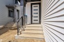 Modern entryway featuring a white door with horizontal lites, concrete steps, and black metal railings - 13128 187 Avenue, Edmonton, AB  - Outdoor With Exterior 