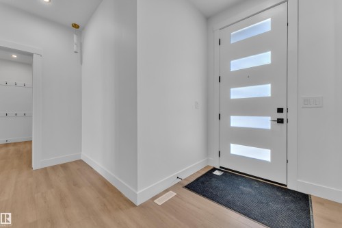 Modern entry door with five horizontal frosted glass panels, matte black hardware, and crisp white trim - 13128 187 Avenue, Edmonton, AB - Indoor Photo Showing Other Room