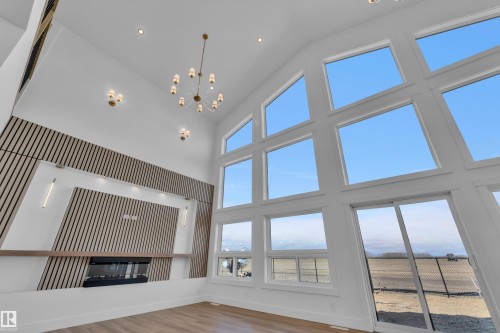 Vaulted ceilings showcasing a contemporary fireplace with a decorative slat wall surround and integrated shelving - 13128 187 Avenue, Edmonton, AB - Indoor Photo Showing Other Room