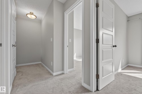 Interior hallway featuring light gray walls, white trim, and light gray carpeting - 15 2072 Wonnacott Way, Edmonton, AB - Indoor Photo Showing Other Room