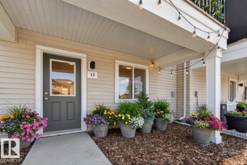 The property features a welcoming entrance with a dark gray door and a number 15 sign - 15 2072 Wonnacott Way, Edmonton, AB - Outdoor With Deck Patio Veranda