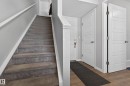 Entryway featuring a carpeted staircase with white trim, light grey walls, and doors with white paneling - 15 2072 Wonnacott Way, Edmonton, AB  - Indoor Photo Showing Other Room 