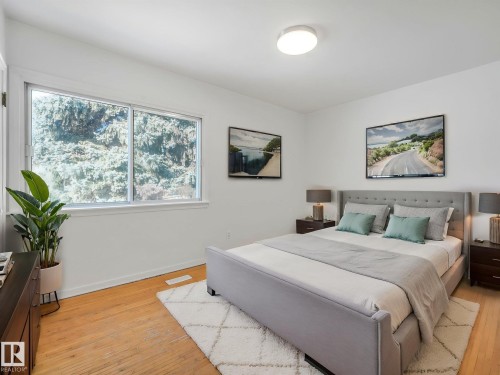 Bedroom with hardwood floors and a window overlooking lush greenery - 10645 62 Avenue, Edmonton, AB - Indoor Photo Showing Bedroom