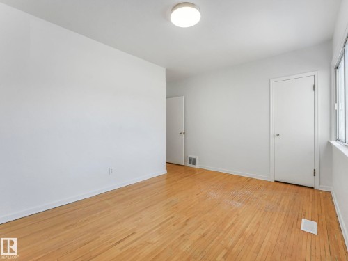 This room features hardwood floors, white walls, and a ceiling-mounted light fixture - 10645 62 Avenue, Edmonton, AB - Indoor Photo Showing Other Room
