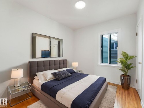 This bright room features a window providing natural light, hardwood floors, and a ceiling light fixture - 10645 62 Avenue, Edmonton, AB - Indoor Photo Showing Bedroom