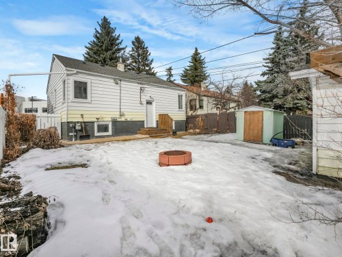 The property features a spacious backyard with a metal storage shed and a fire pit - 10645 62 Avenue, Edmonton, AB - Outdoor