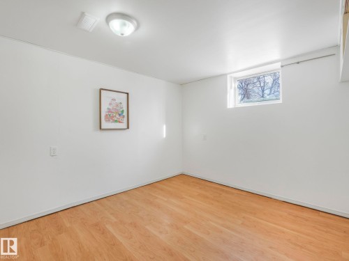 This room features light wood flooring, white walls, and a window providing natural light - 10645 62 Avenue, Edmonton, AB - Indoor Photo Showing Other Room