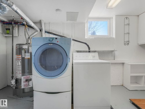The laundry area features a washer and dryer, a water heater, and a window providing natural light - 10645 62 Avenue, Edmonton, AB - Indoor Photo Showing Laundry Room