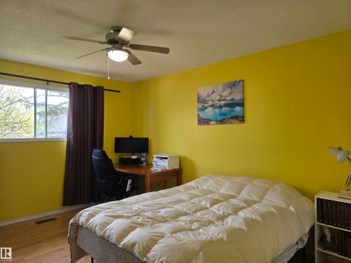 Room featuring a window with natural light, wood-finish flooring, and a ceiling fan with integrated lighting - 4029 55 Avenue, Drayton Valley, AB - Indoor Photo Showing Bedroom