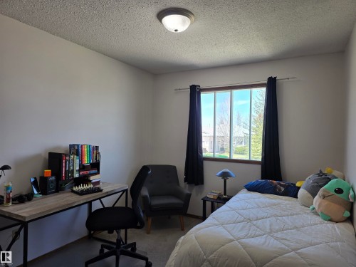 Interior room featuring neutral wall paint, a textured ceiling, and a flush-mount ceiling light - 4029 55 Avenue, Drayton Valley, AB - Indoor Photo Showing Bedroom