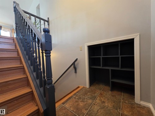 Hardwood staircase with dark balusters and handrail - 4029 55 Avenue, Drayton Valley, AB - Indoor Photo Showing Other Room