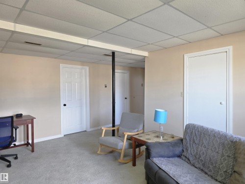 Carpeted interior space featuring neutral wall paint and a drop ceiling - 4029 55 Avenue, Drayton Valley, AB - Indoor