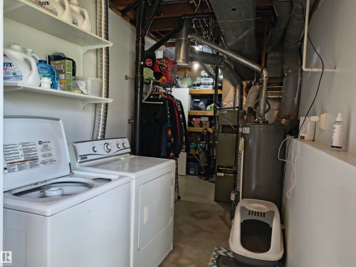 Dedicated laundry area featuring white wall shelving and exposed utility lines - 4029 55 Avenue, Drayton Valley, AB - Indoor Photo Showing Laundry Room