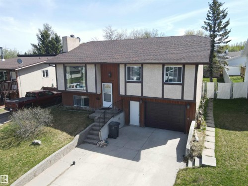 Split-level residence featuring a dark asphalt shingle roof, stucco and wood siding, and a single-car garage - 4029 55 Avenue, Drayton Valley, AB - Outdoor