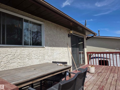 Expansive wooden deck featuring perimeter railing, stucco exterior, and sliding glass door access - 4029 55 Avenue, Drayton Valley, AB - Outdoor With Deck Patio Veranda With Exterior