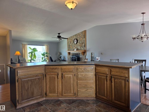 Kitchen featuring a peninsula with wood cabinetry, dark countertops, and tile flooring - 4029 55 Avenue, Drayton Valley, AB - Indoor