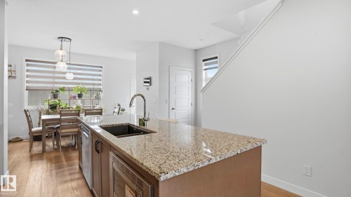 Kitchen island with a granite countertop and an undermount sink - 17364 2 Street, Edmonton, AB - Indoor Photo Showing Kitchen With Double Sink With Upgraded Kitchen