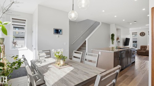 Open-concept main living area with wood-finish flooring, recessed lighting, and a modern staircase - 17364 2 Street, Edmonton, AB - Indoor Photo Showing Dining Room