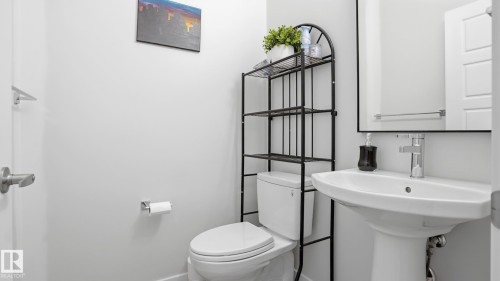 Pedestal sink with chrome faucet, complemented by a contemporary wall-mounted mirror - 17364 2 Street, Edmonton, AB - Indoor Photo Showing Bathroom