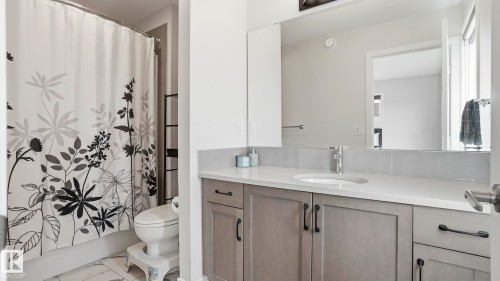 Bathroom featuring a single vanity with gray cabinetry, a white countertop, and a rectangular undermount sink - 17364 2 Street, Edmonton, AB - Indoor Photo Showing Bathroom