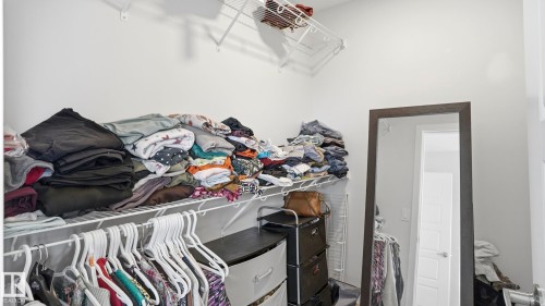 Walk-in closet featuring white wire shelving, white walls, and a full-length mirror with a dark frame - 17364 2 Street, Edmonton, AB - Indoor With Storage