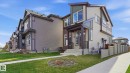 Contemporary exterior featuring a covered entry, light-toned siding, dark trim accents, and multiple large windows - 17364 2 Street, Edmonton, AB  - Outdoor 