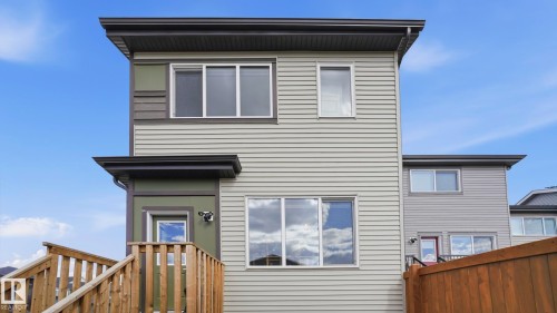 Contemporary facade featuring light-colored horizontal siding, contrasting dark trim, and multiple windows - 17364 2 Street, Edmonton, AB - Outdoor