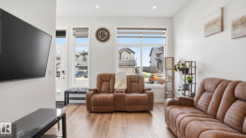 Living area featuring wood-finish flooring, recessed lighting, and expansive windows - 17364 2 Street, Edmonton, AB - Indoor Photo Showing Living Room