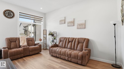 Bright living area featuring wood-finish flooring, a large window with horizontal blinds, recessed lighting, and white baseboards - 17364 2 Street, Edmonton, AB - Indoor Photo Showing Living Room