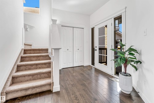 Foyer featuring wood-finish flooring, white trim, and a carpeted staircase with white balusters - 2292 Casey Crescent, Edmonton, AB - Indoor Photo Showing Other Room