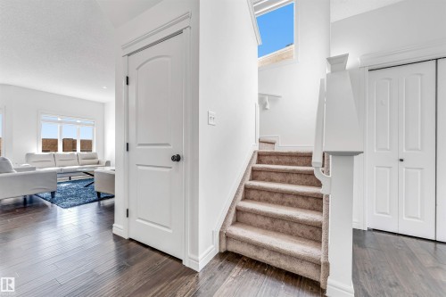 Carpeted staircase with white balustrade and natural light from an overhead window - 2292 Casey Crescent, Edmonton, AB - Indoor Photo Showing Other Room