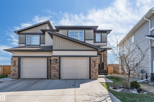 Modern two-story residence featuring a dual-tone facade with dark siding accents, light siding panels, and brick veneer detailing - 2292 Casey Crescent, Edmonton, AB - Outdoor With Facade