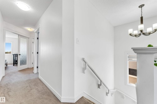 Carpeted hallway with white walls and trim, featuring a flush-mount ceiling light - 2292 Casey Crescent, Edmonton, AB - Indoor Photo Showing Other Room