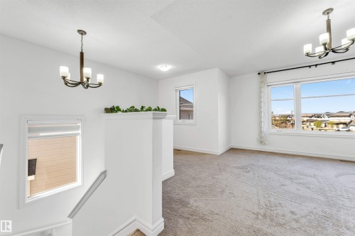 Open concept upper-level space featuring broadloom carpeting and multiple windows - 2292 Casey Crescent, Edmonton, AB - Indoor Photo Showing Other Room
