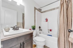 Bathroom featuring a dark wood-finish vanity with a light countertop and an integrated sink - 