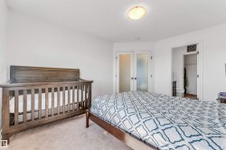 Carpeted bedroom with white walls and a ceiling-mounted light fixture - 