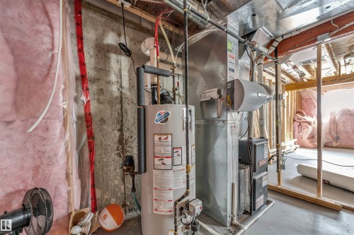 Mechanical room featuring a water heater, furnace, and exposed concrete walls - 2292 Casey Crescent, Edmonton, AB - Indoor Photo Showing Basement