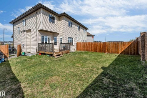 Expansive backyard featuring a wood deck, wood privacy fence, and a spacious lawn area - 2292 Casey Crescent, Edmonton, AB - Outdoor