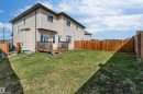 Expansive backyard featuring a wood deck, wood privacy fence, and a spacious lawn area - 2292 Casey Crescent, Edmonton, AB  - Outdoor 