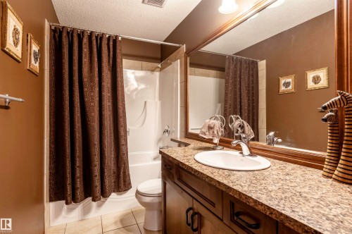 Bathroom featuring a spacious vanity with an integrated sink, a large wall-mounted mirror, and a shower-over-tub combination - 19 Newton Place, St. Albert, AB - Indoor Photo Showing Bathroom