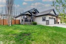 Single-story residence featuring light-colored siding, a dark shingled roof, and a prominent attached garage with a concrete driveway - 19 Newton Place, St. Albert, AB  - Outdoor 