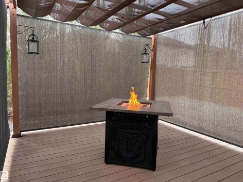 Outdoor living area featuring a pergola with retractable canopy, composite decking, and privacy screens - 19 Newton Place, St. Albert, AB - Indoor