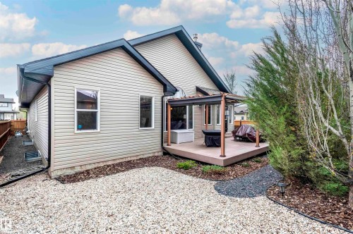 Rear exterior of a single-story residence featuring light-colored horizontal siding and dark trim - 19 Newton Place, St. Albert, AB - Outdoor With Deck Patio Veranda With Exterior