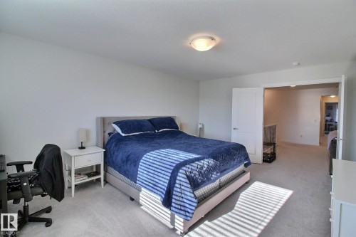 Spacious bedroom with light gray carpeting and white walls - 121 Stiles Bend, Leduc, AB - Indoor Photo Showing Bedroom
