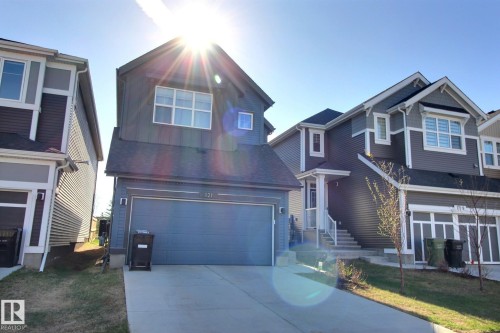 Modern two-story residence featuring a dark gray siding exterior with white trim accents and a prominent attached garage - 121 Stiles Bend, Leduc, AB - Outdoor With Facade