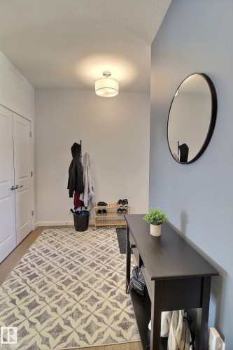 Entryway featuring light-toned wood-finish flooring, a contemporary flush mount ceiling light, and a built-in closet with double doors - 121 Stiles Bend, Leduc, AB - Indoor
